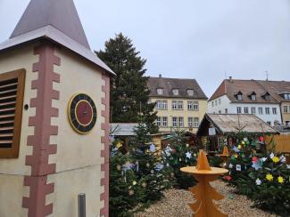 Links der Turm der Wagenkirche, dahinter der Weihnachtsbaum auf dem Martkplatz und vor den Marktständen kleinere Wunschbäume, an denen Zettel mit Weihnachtswünschen hängen