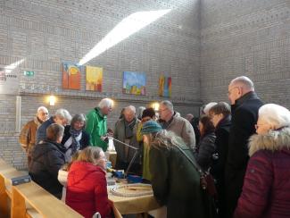 Eine Szene aus dem Special zum Jubiläum "zehn Jahre Repair-Café": Menschen drängeln sich in der Kirche an den Tischen des Repair-Cafés