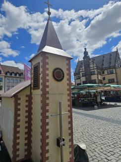 Die Wagenkirche bei leicht bewölkten blauem Himmel vor dem Schweinfurter Rathaus